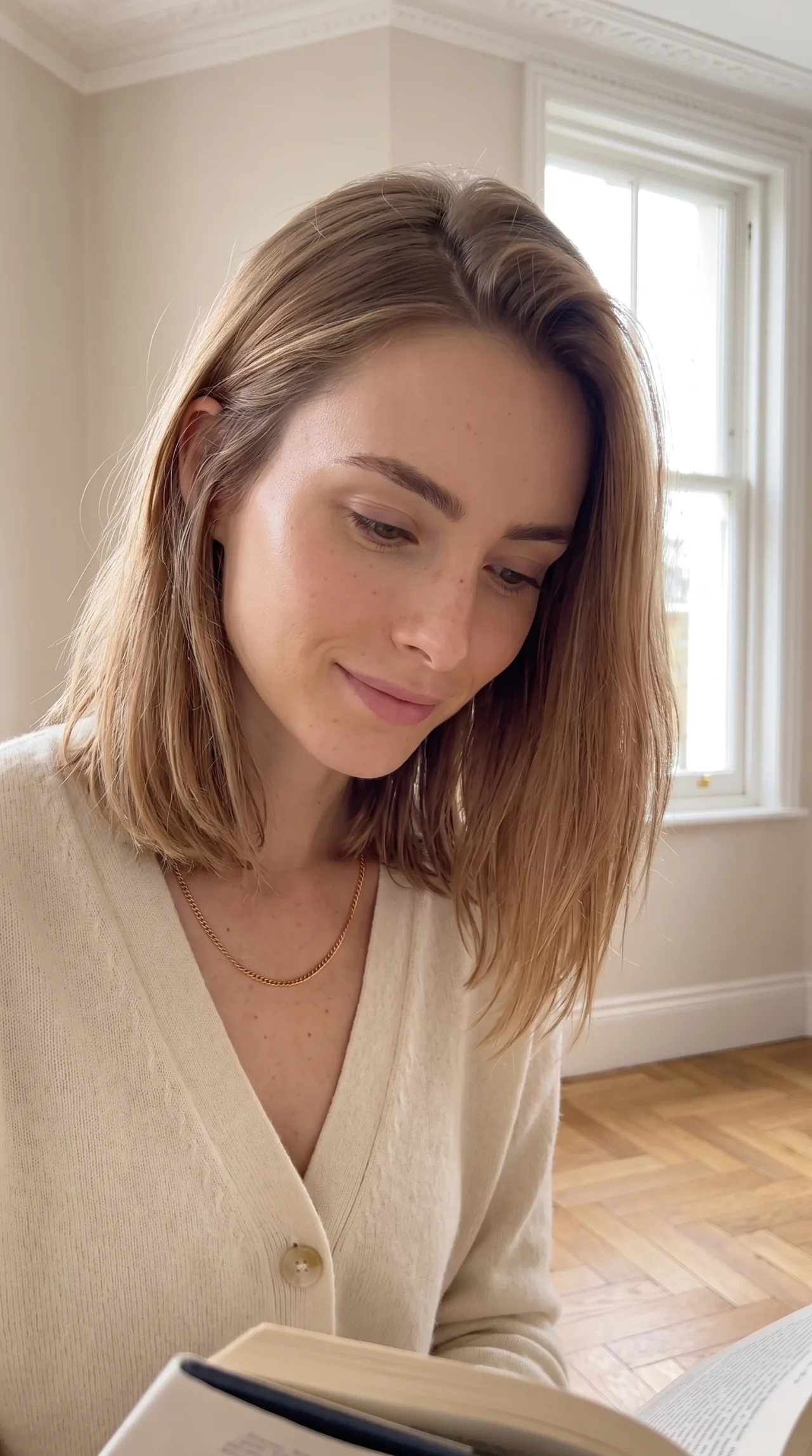 Close portrait of a woman with shoulder-length hair in soft window light